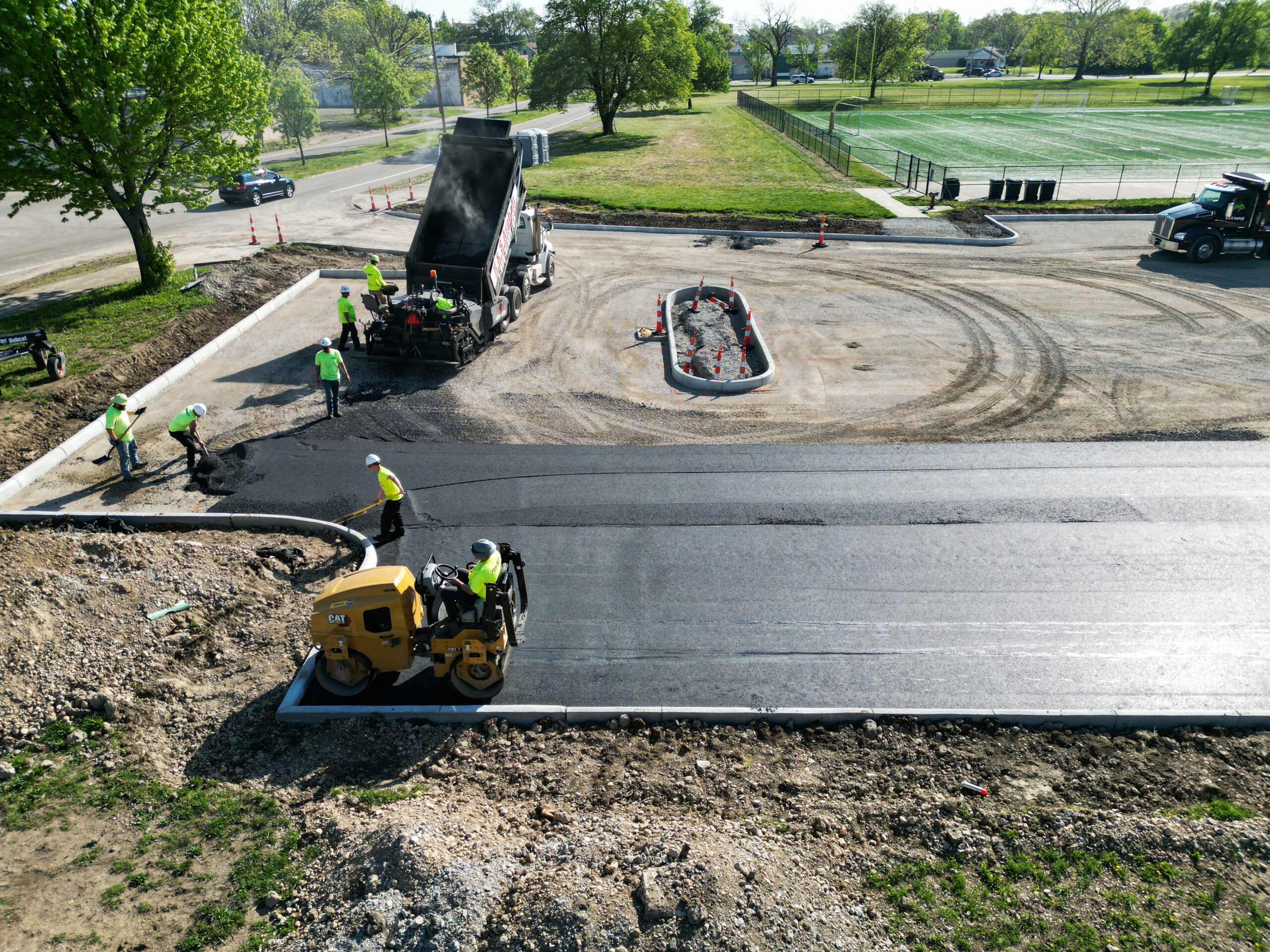 Asphalt pavers working together to pave a new parking lot