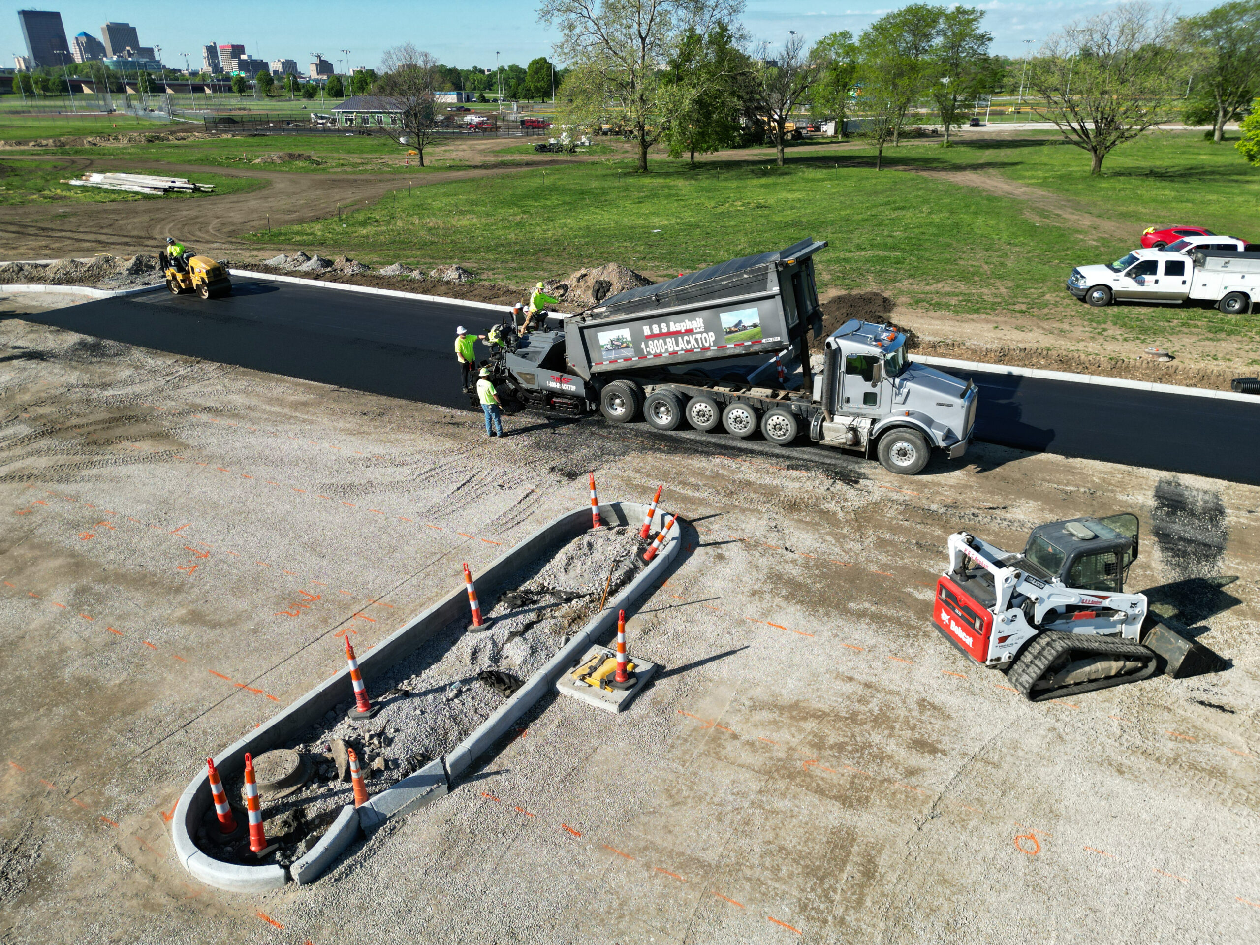 Asphalt truck pouring asphalt onto parking lot